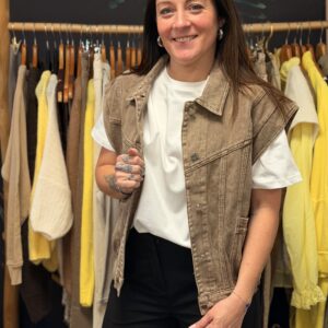 Femme aux cheveux longs bruns portant une veste sans manches denim beige used effet biker.