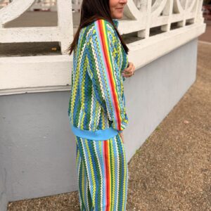 femme cheveux brun porte un pantalon style jogging en maille couleur bleu, vert