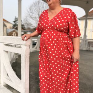 femme aux cheveux court porte robe longue corail à pois