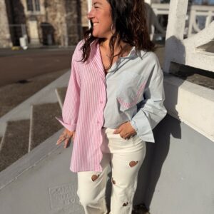 Femme aux cheveux brin mi long porte une chemise bi colore tendance rose et bleu, avec un peu de rayures
