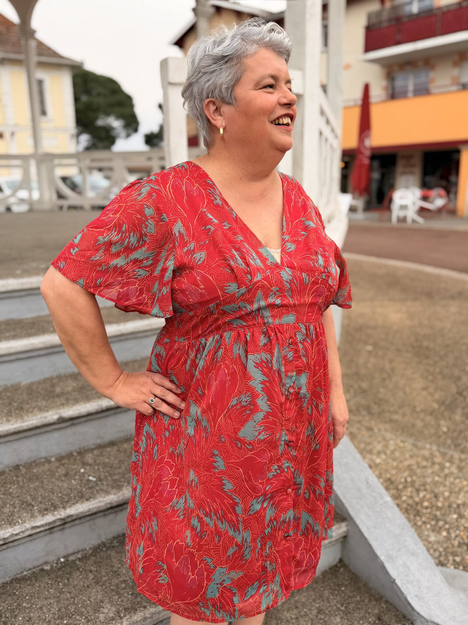 femme aux cheveux court porte robe courte rouge à motif floral