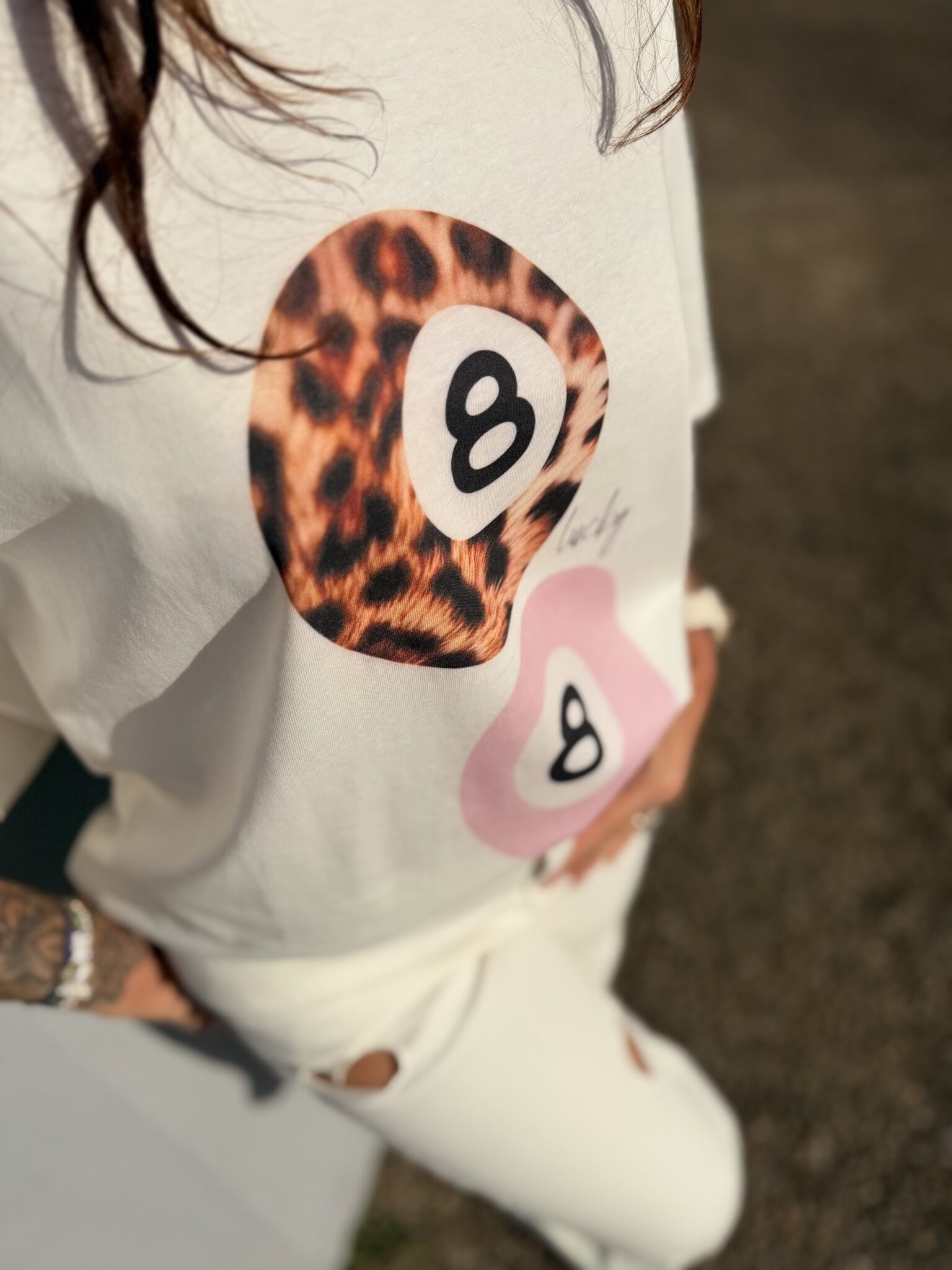 Femme aux cheveux brin mi long porte un tee-shirt tendance léopard et rose