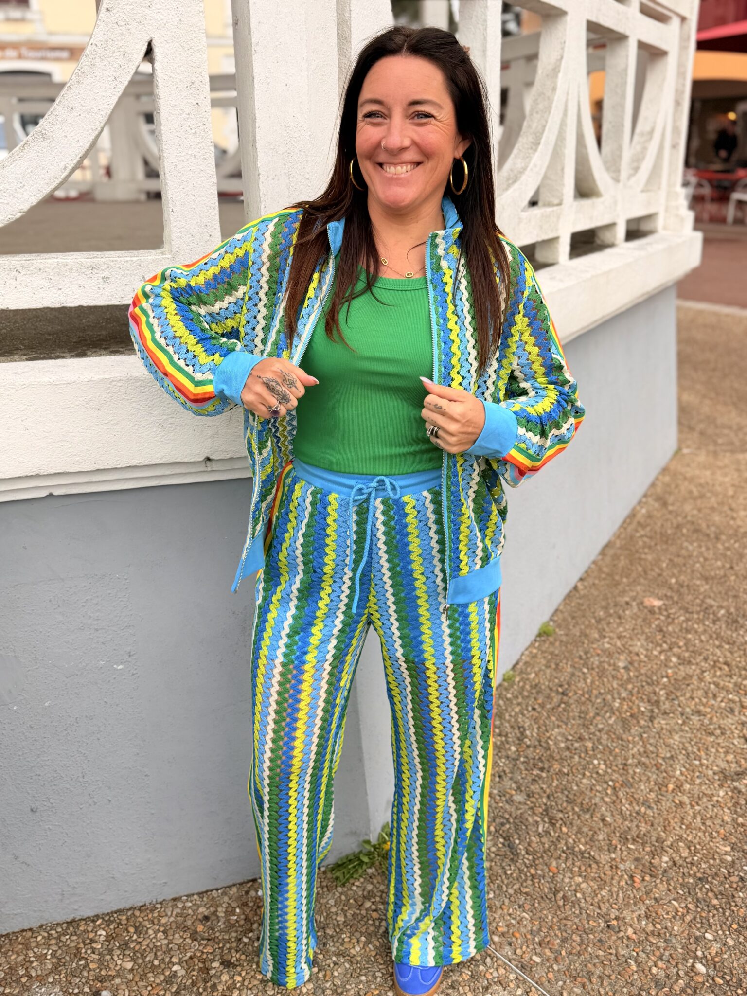 femme cheveux brun porte un pantalon style jogging en maille couleur bleu, vert