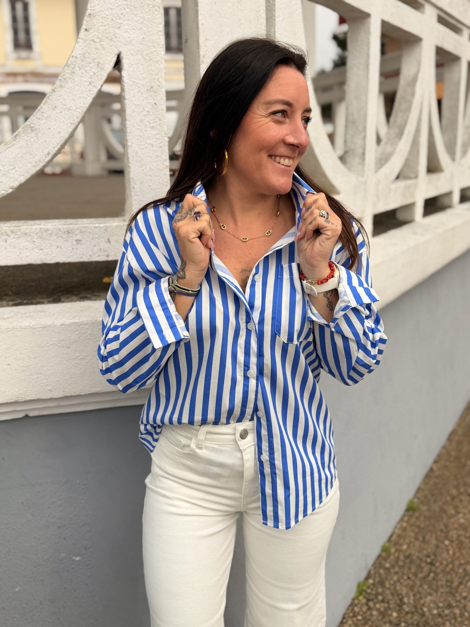 femme brune porte une chemise rayée bleu et blanche