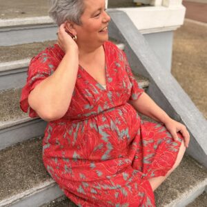 femme aux cheveux court porte robe courte rouge à motif floral