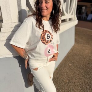 Femme aux cheveux brin mi long porte un tee-shirt tendance léopard et rose
