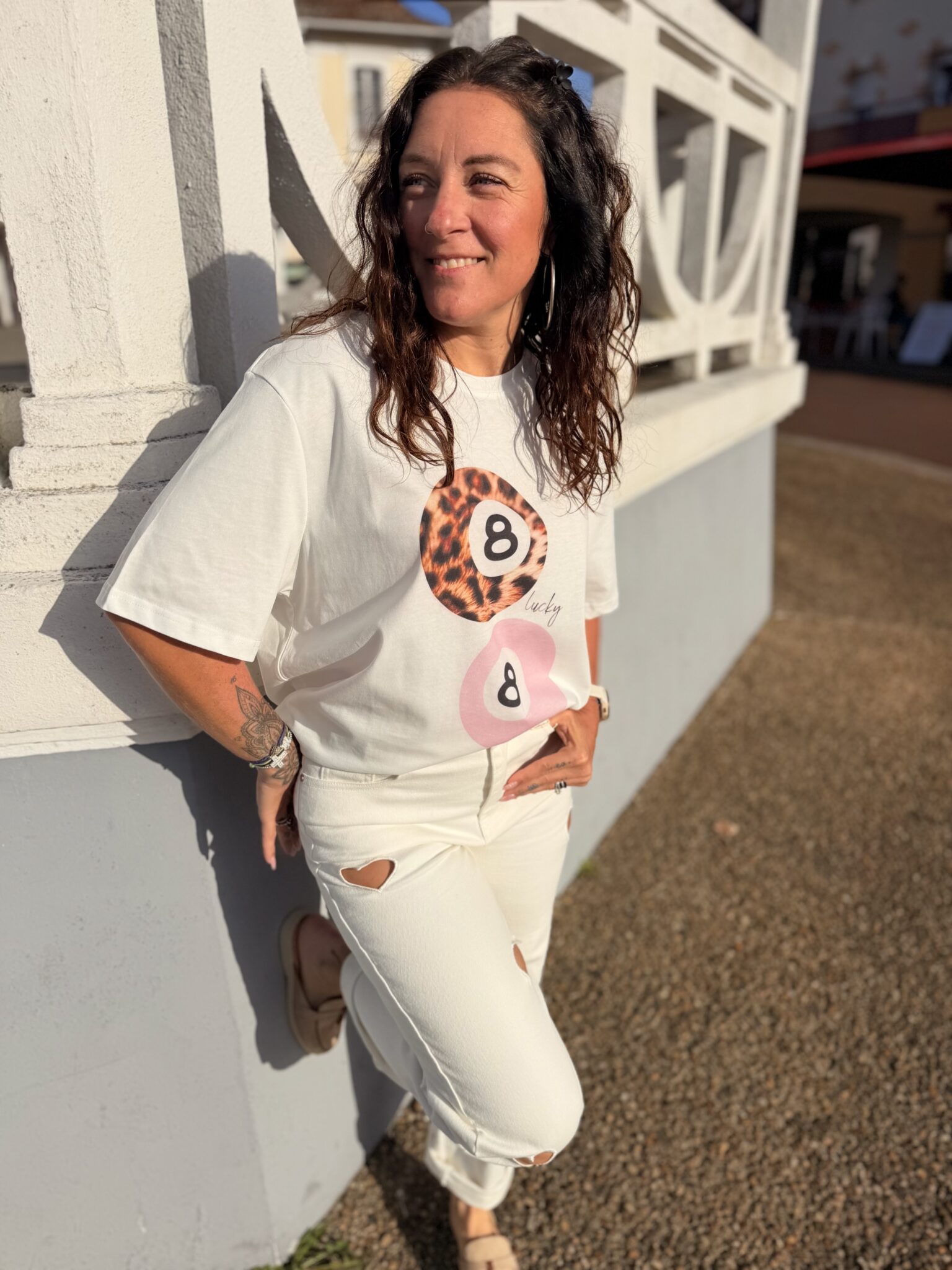 Femme aux cheveux brin mi long porte un tee-shirt tendance léopard et rose