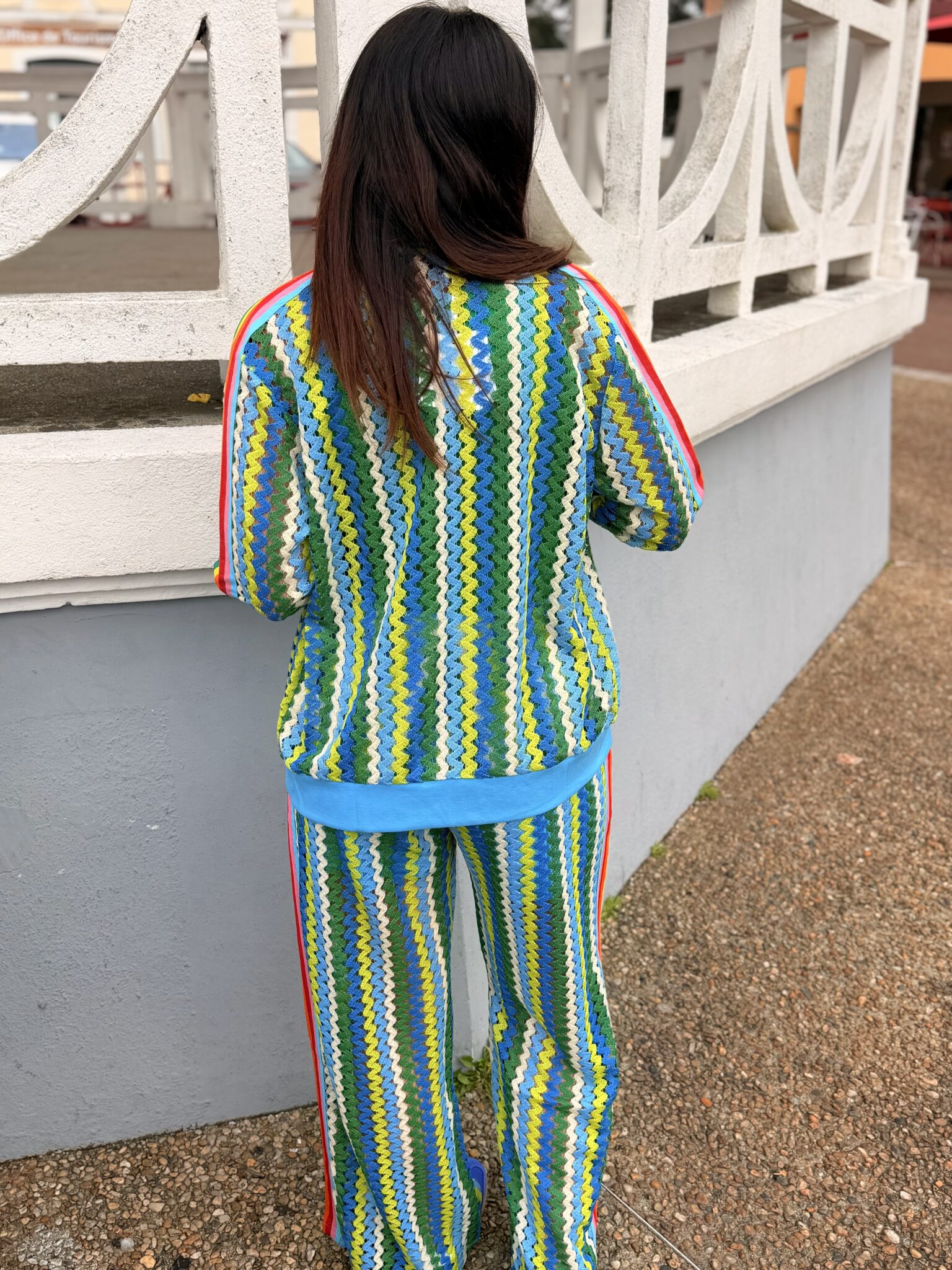 femme cheveux brun porte un pantalon style jogging en maille couleur bleu, vert
