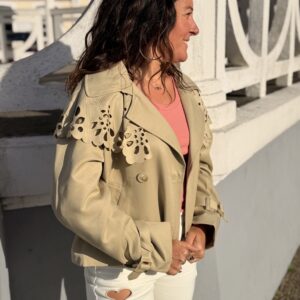 Femme aux cheveux brin mi long porte une veste beige avec une cape en dentelle originale et tendance