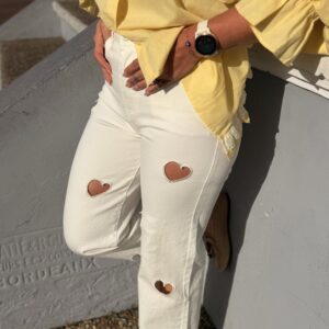 femme portant un pantalon blanc aux découpes en forme de coeurs tendance et originale