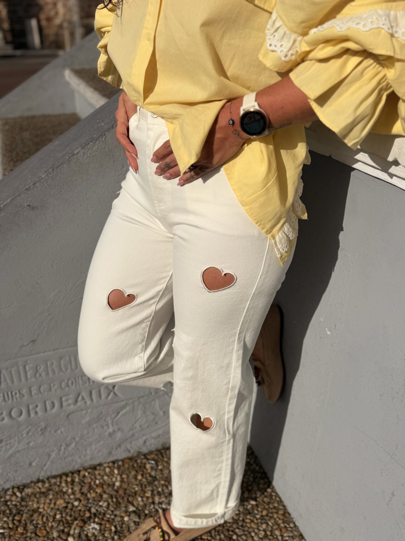 femme portant un pantalon blanc aux découpes en forme de coeurs tendance et originale