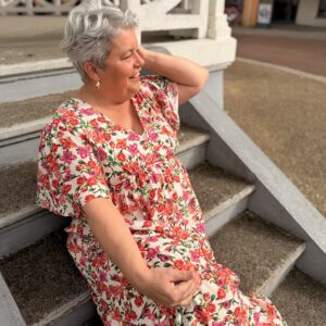 femme aux cheveux court porte robe longue fleurie