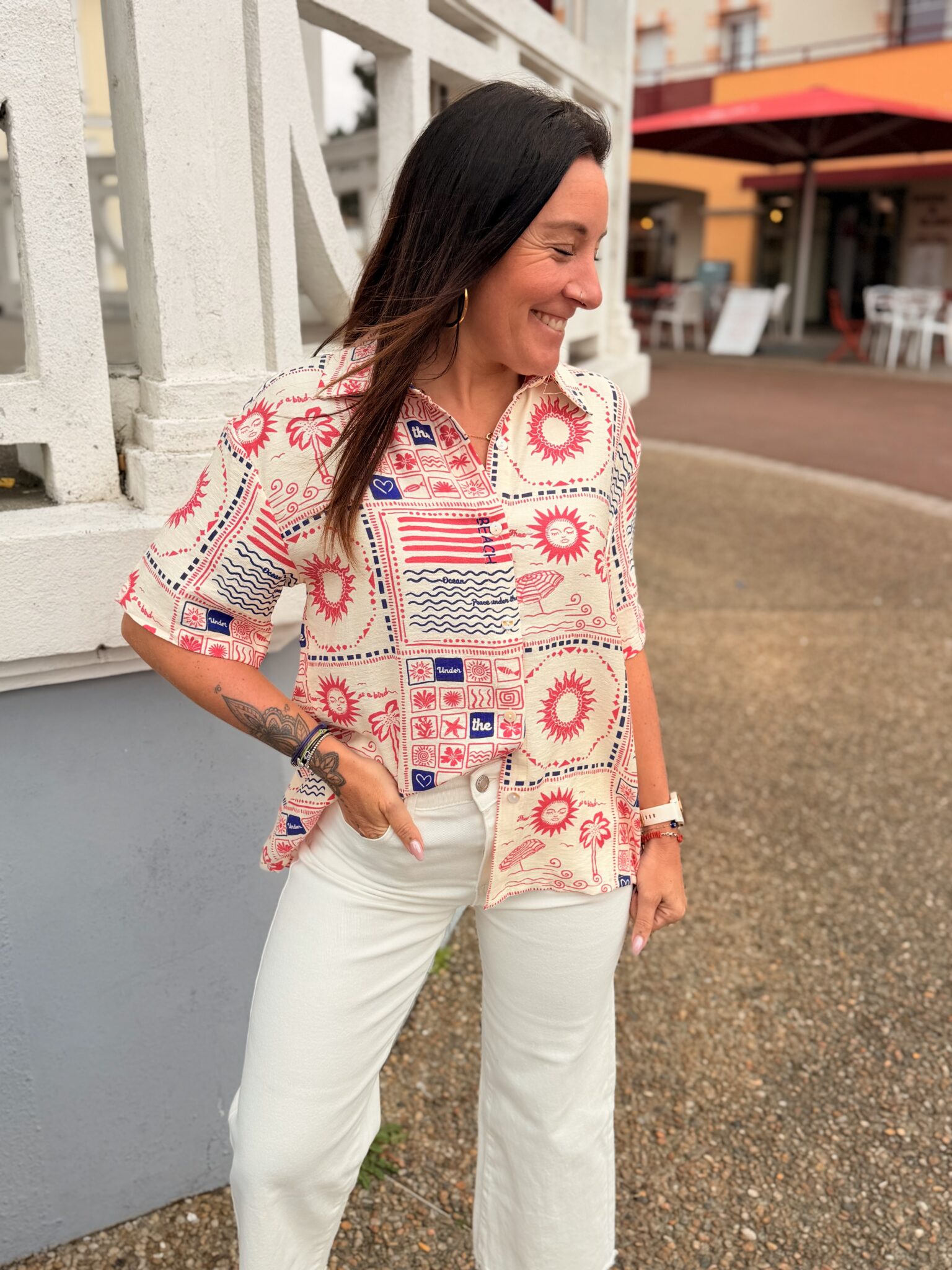 femme cheveux mi long brune porte chemise courte motif Summer soleil, palmiers, ouverte dans le dos