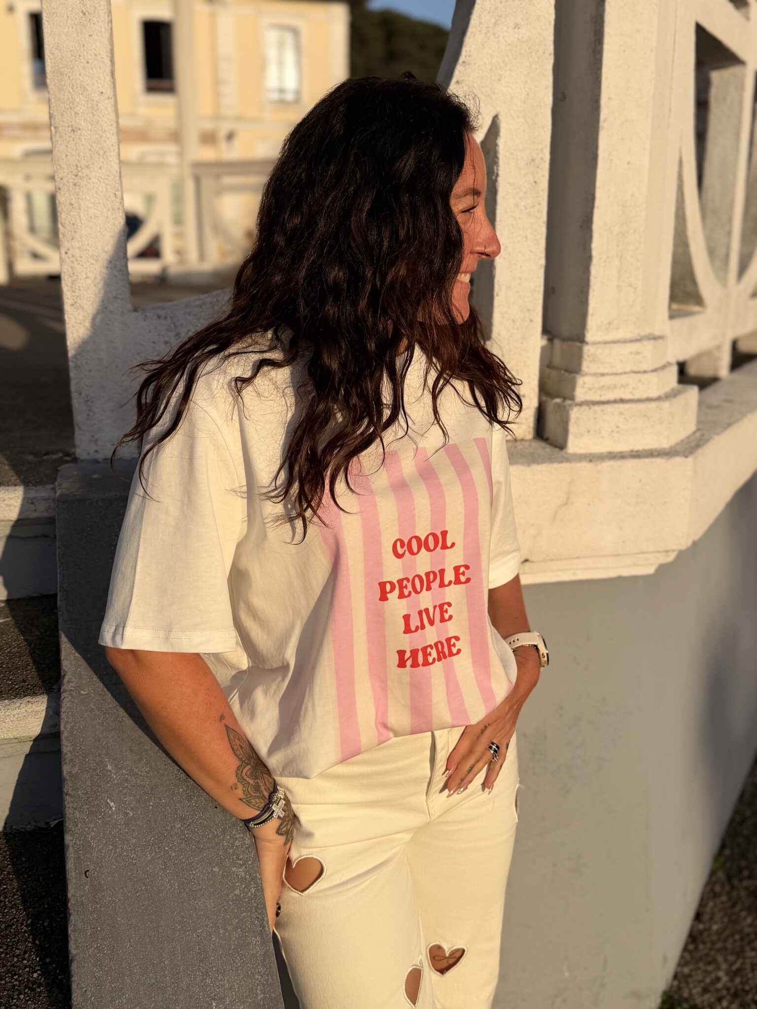 Femme aux cheveux brin mi long porte un tee-shirt tendance cool people rose et rouge