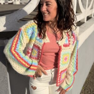 femme aux cheveux mi long brun porte un gilet en maille multicolore doux et tendance