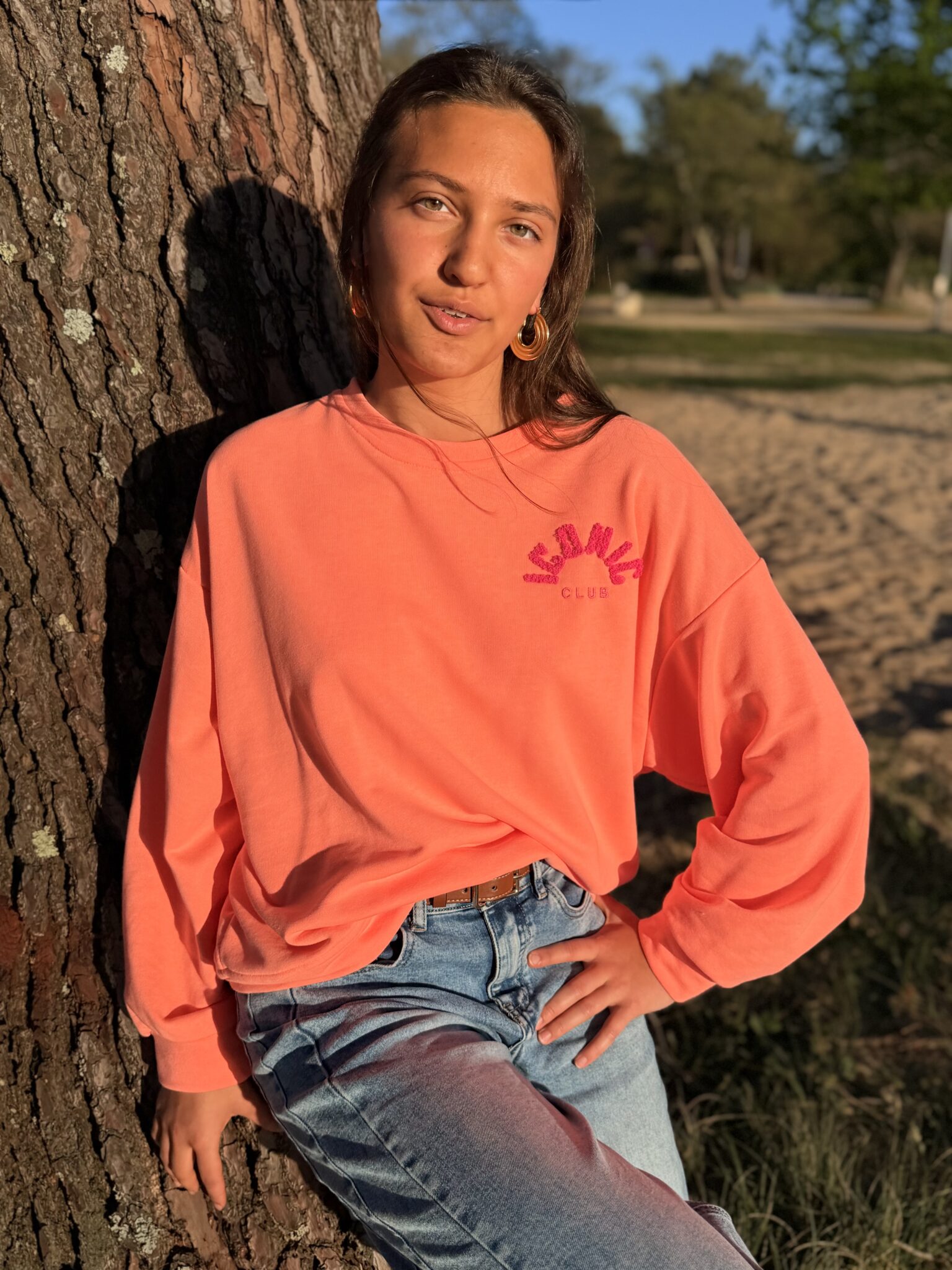 femme brune porte un sweat avec inscription iconic devant et derrière