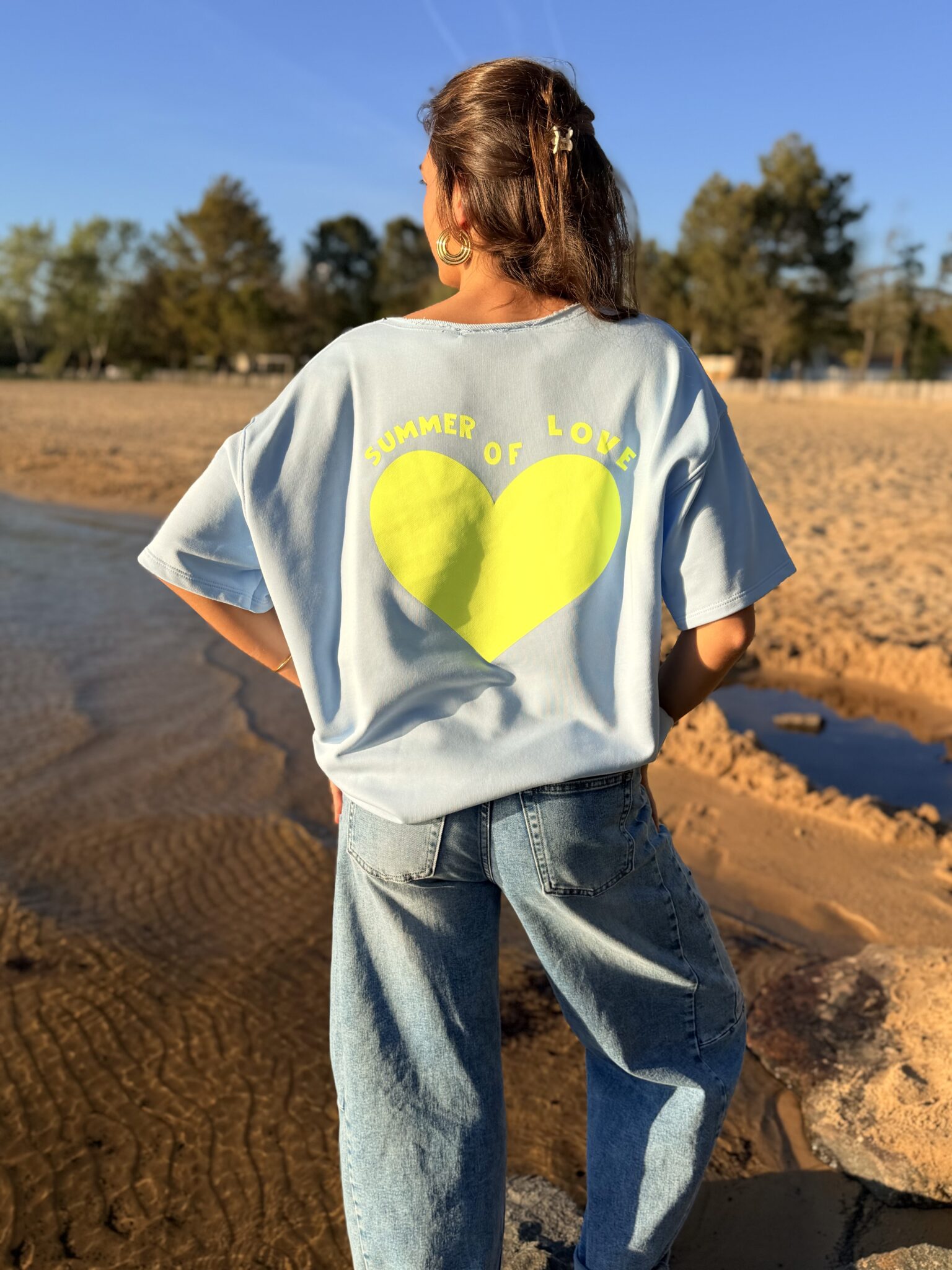 femme brune porte un sweat avec inscription devant et derrière Summer of love