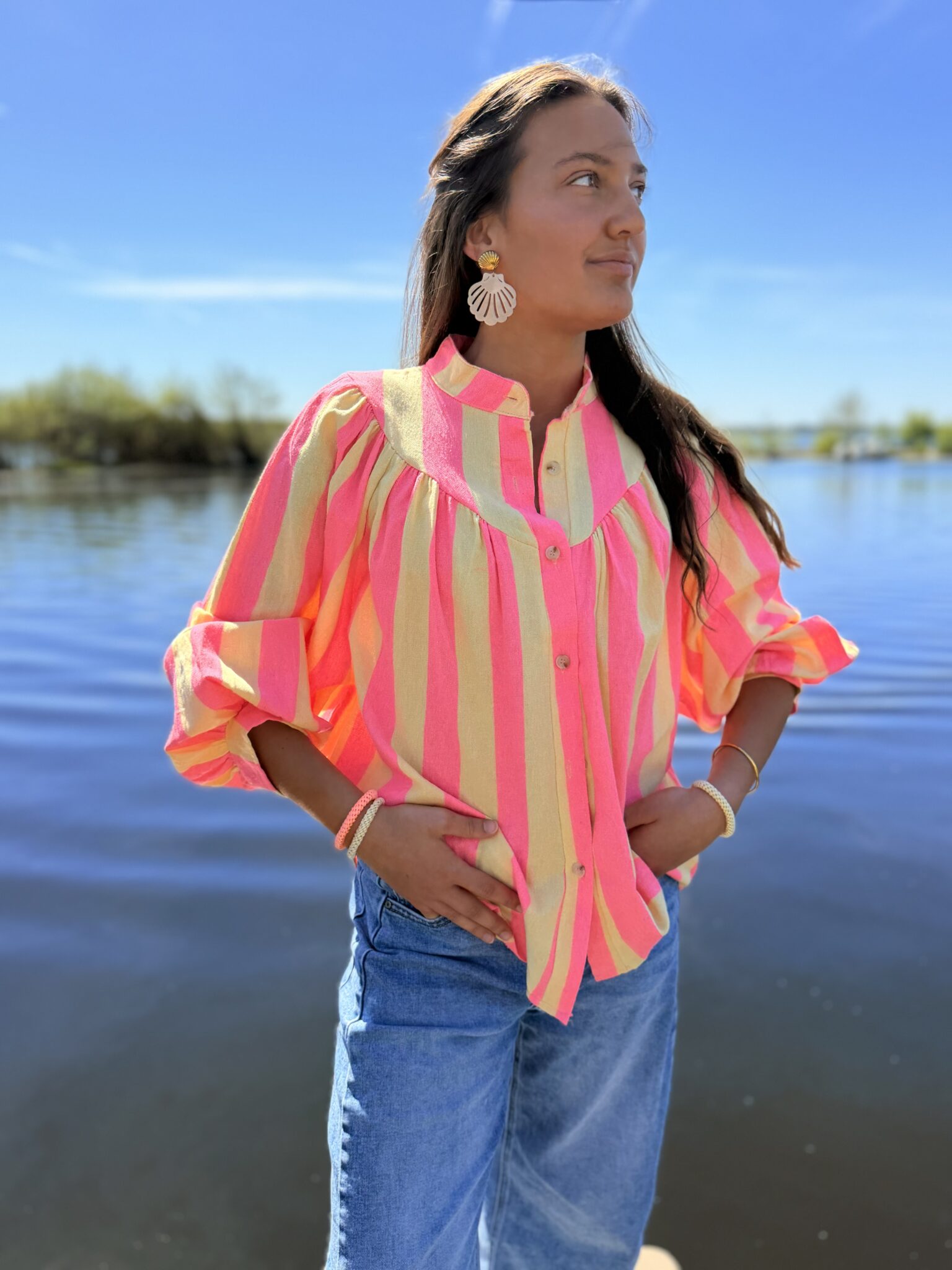 femme brune porte blouse rayé rose et jaune