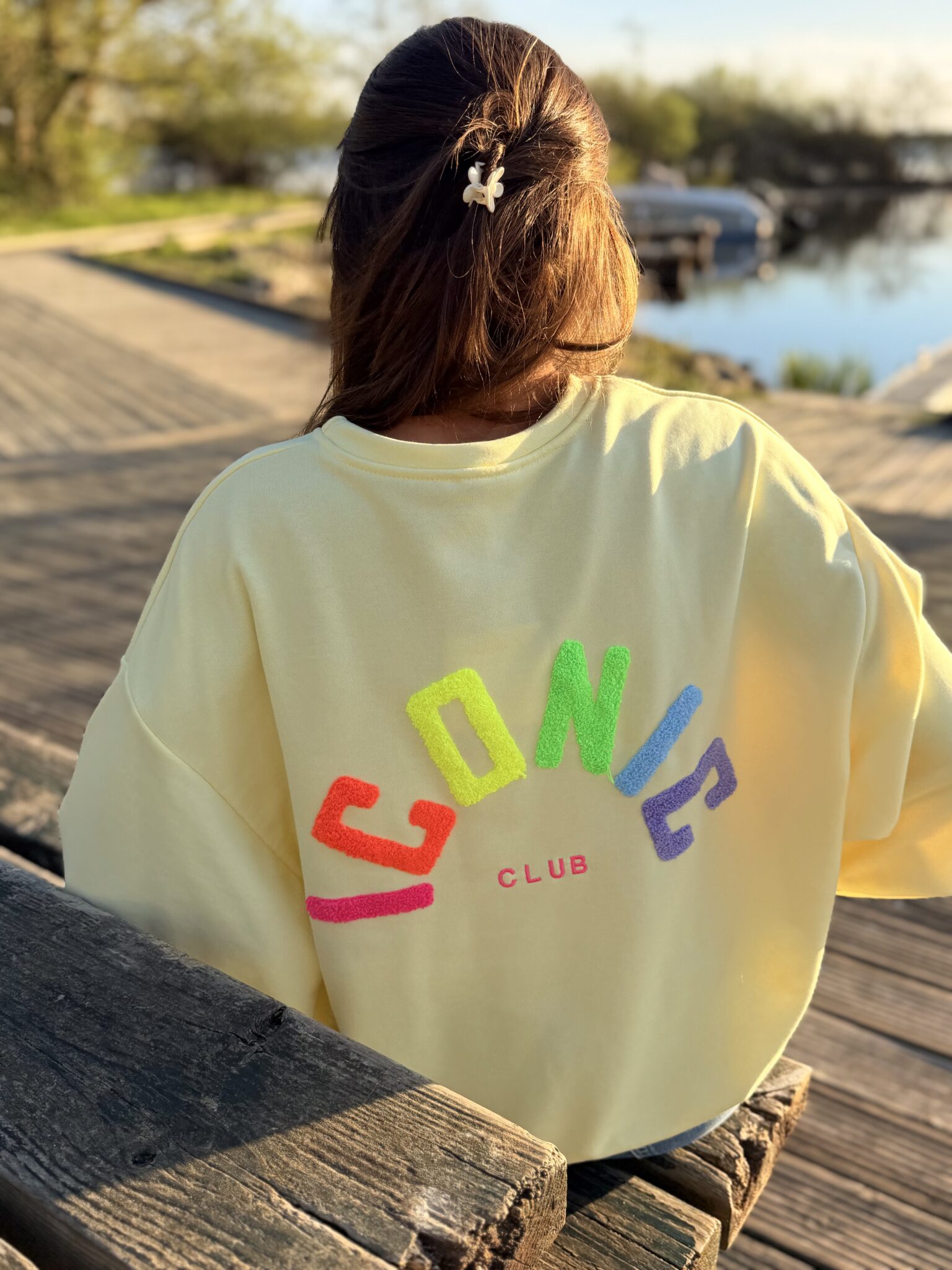 femme brune porte un sweat avec inscription iconic devant et derrière