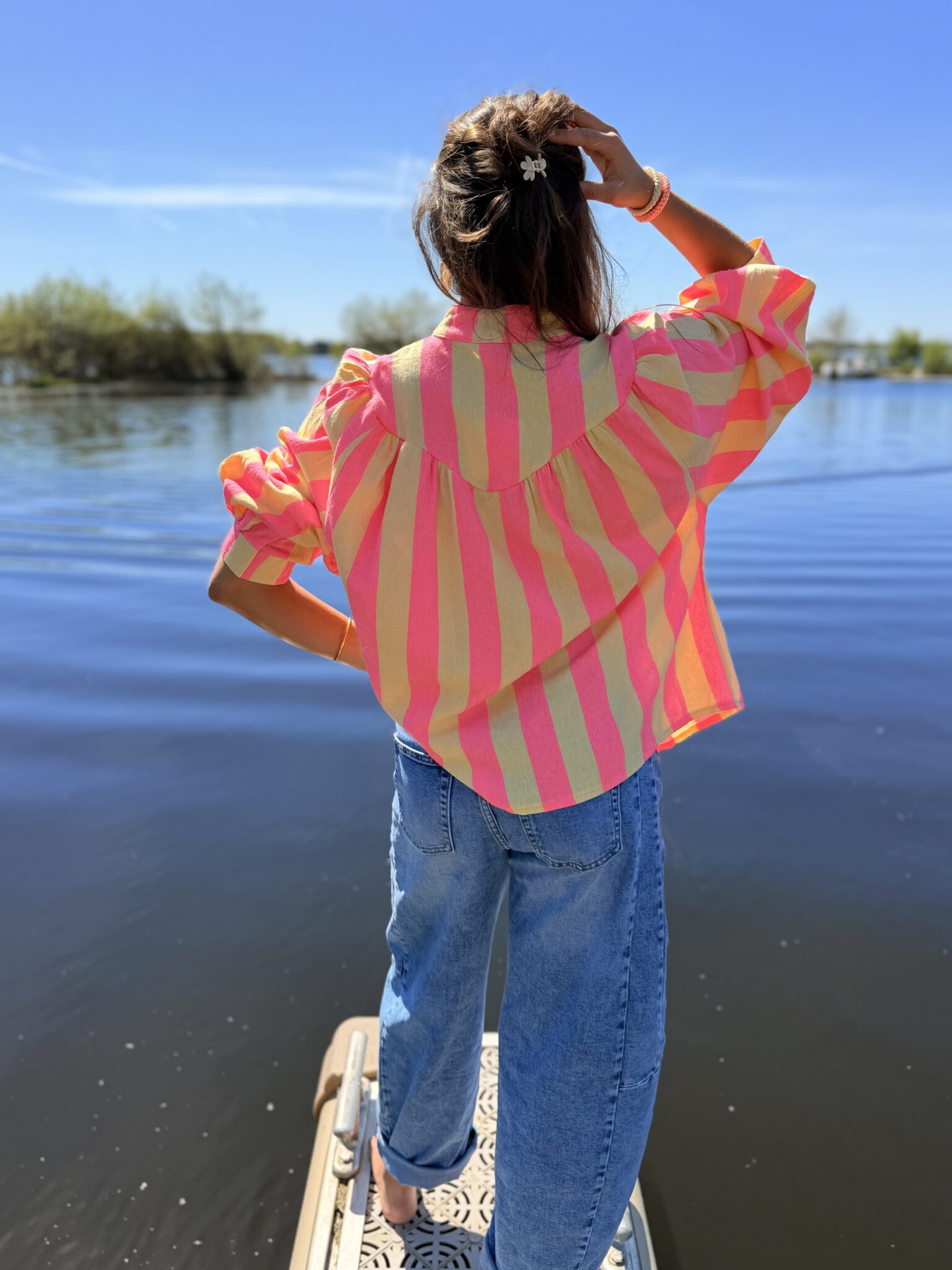 femme brune porte blouse rayé rose et jaune