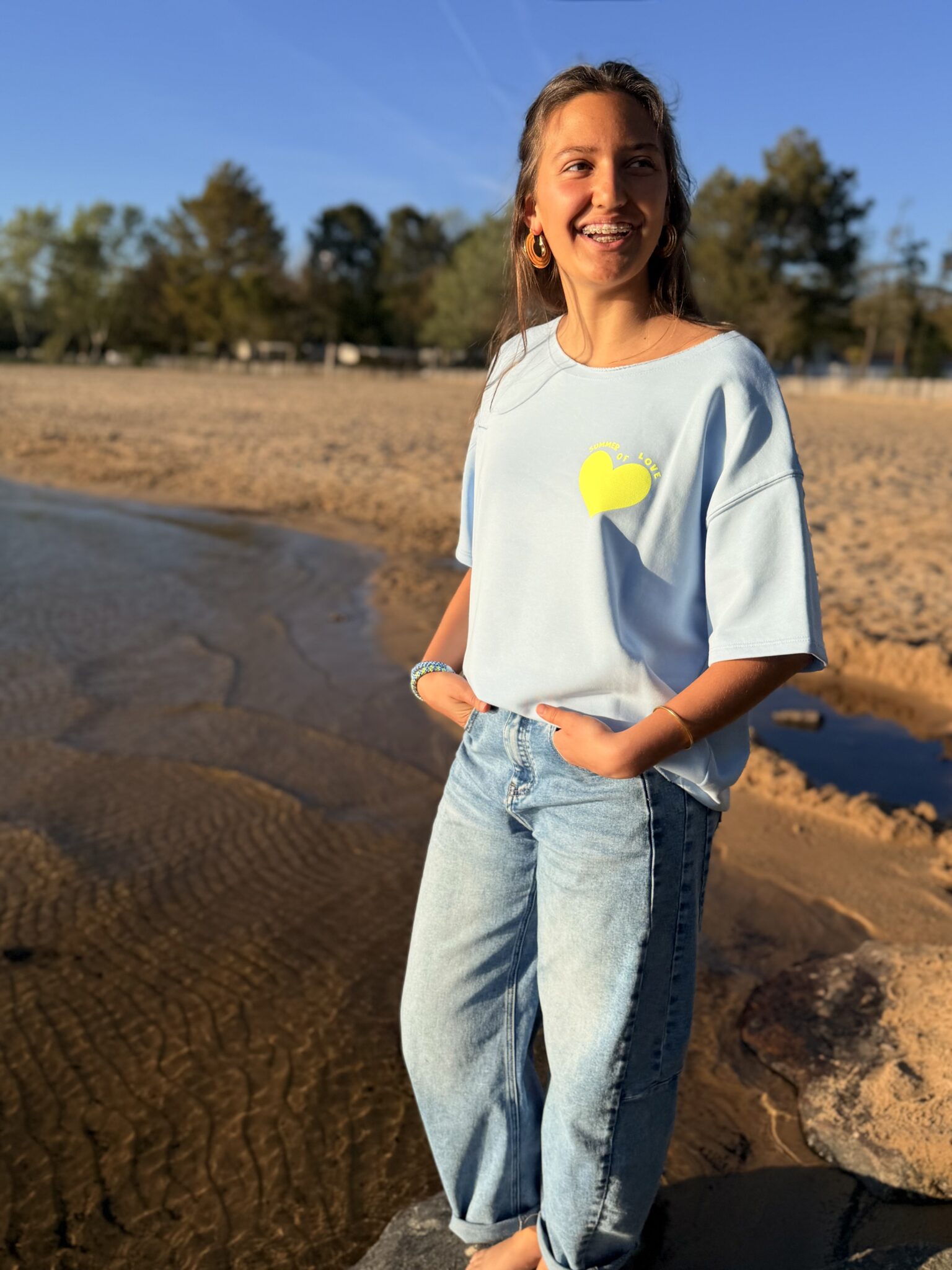 femme brune porte un sweat avec inscription devant et derrière Summer of love