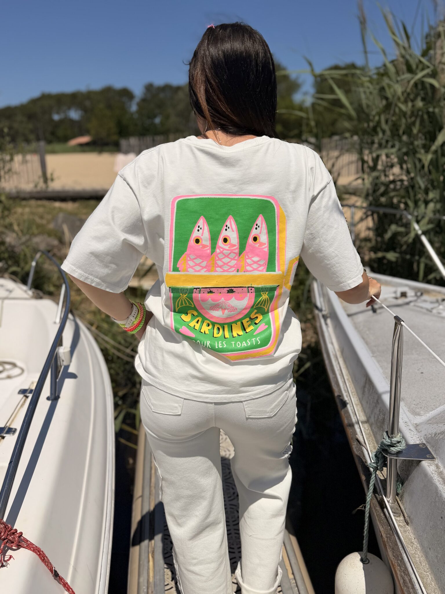 femme brune porte t-shirt blanc avec inscription sardines dans le dos