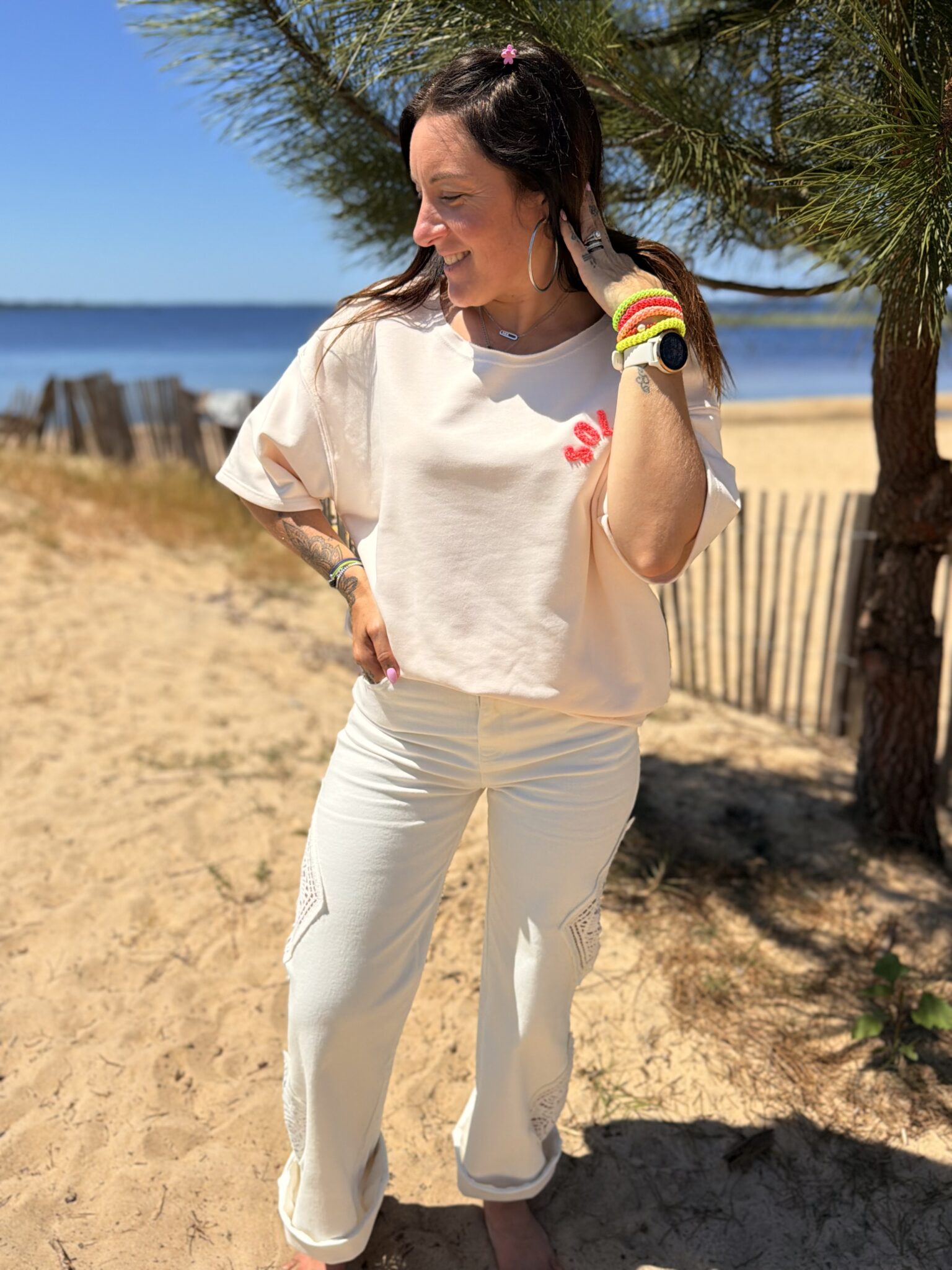 femme brune porte t-shirt oversize écriture dans le dos soleil couleur pêche