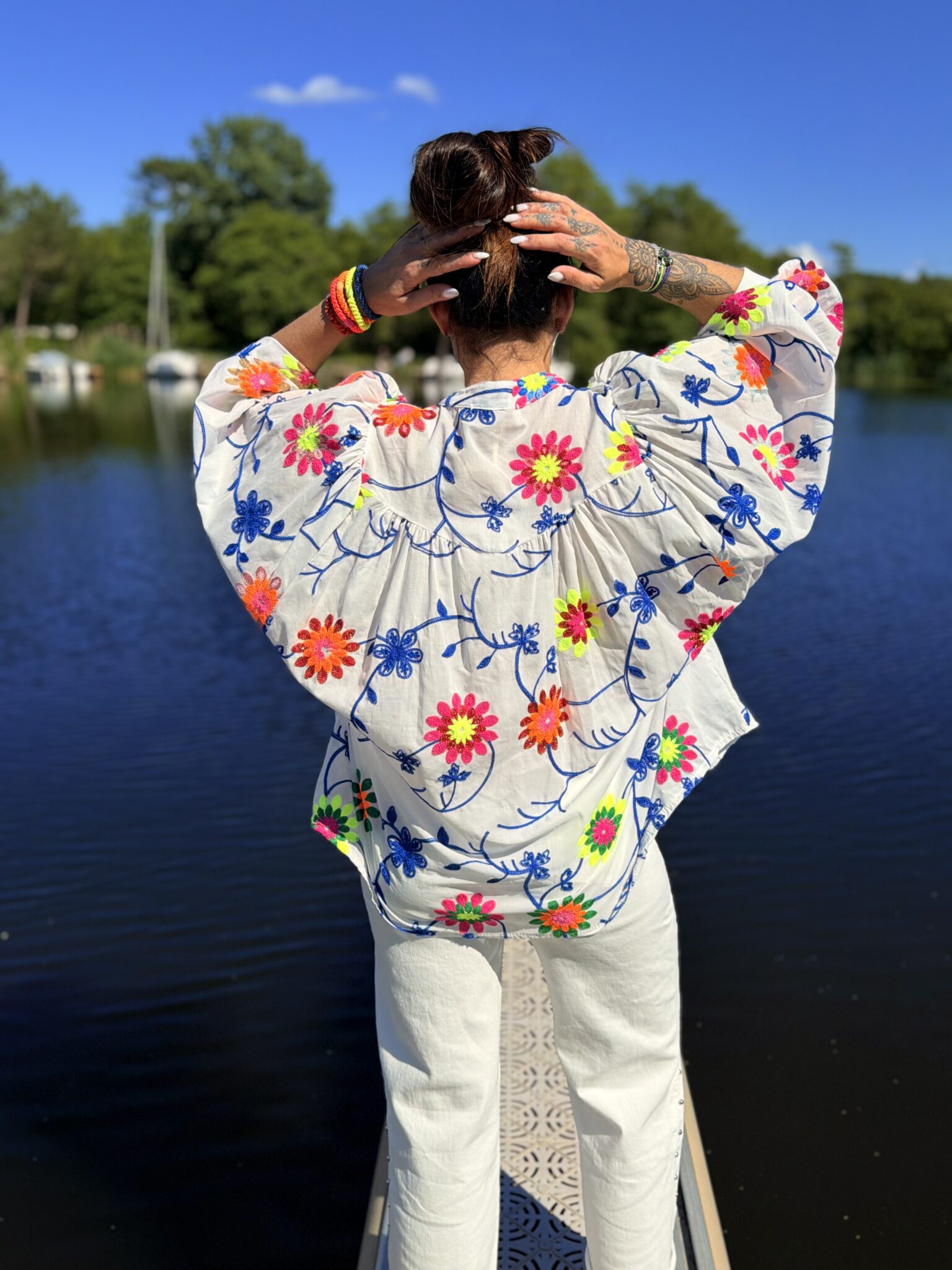 femme brune portant blouse blanche à broderies