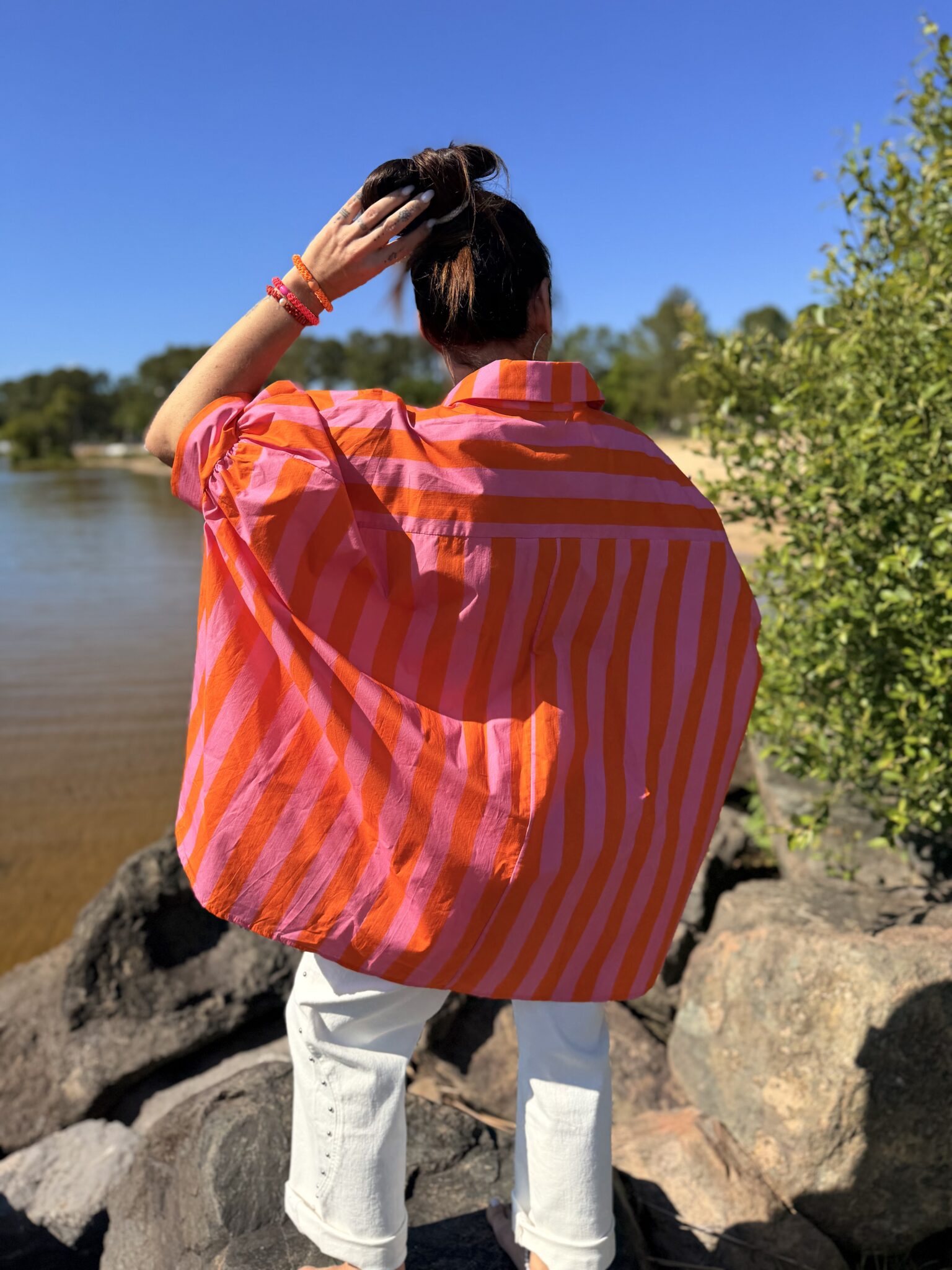 femme brune portant chemise rayée rose orange