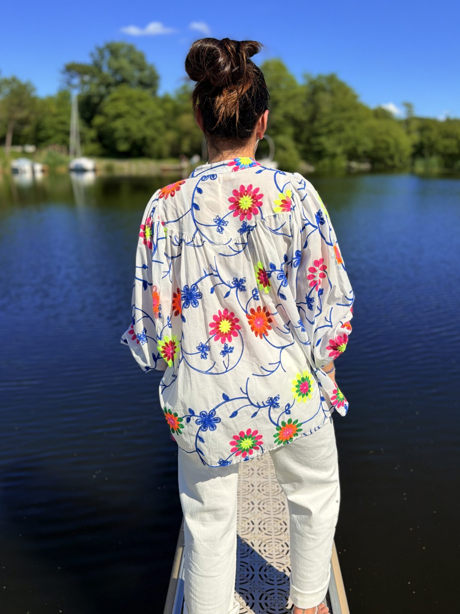 femme brune portant blouse blanche à broderies