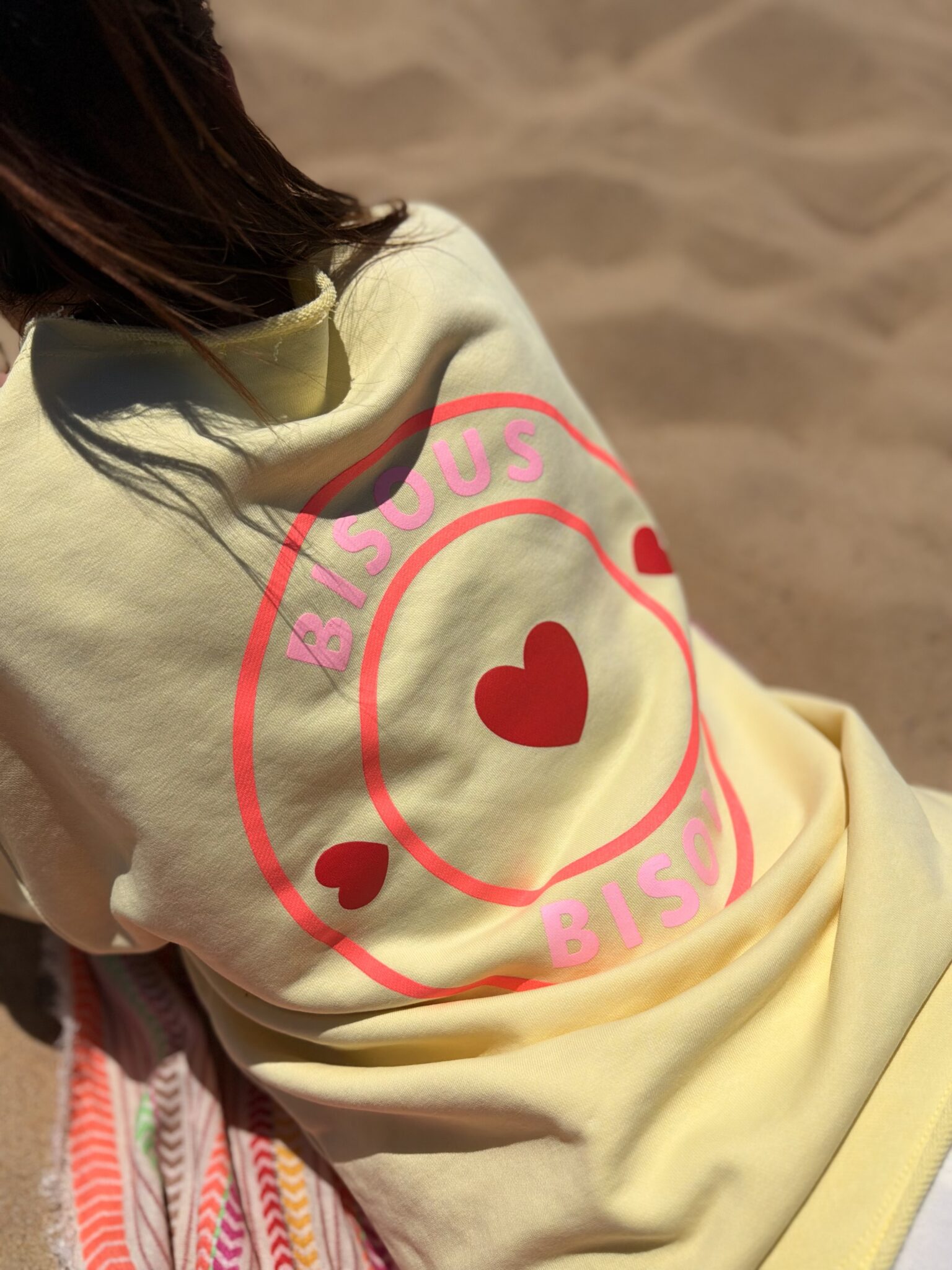 femme brune porte t-shirt oversize avec imprimé coeurs écriture bisous