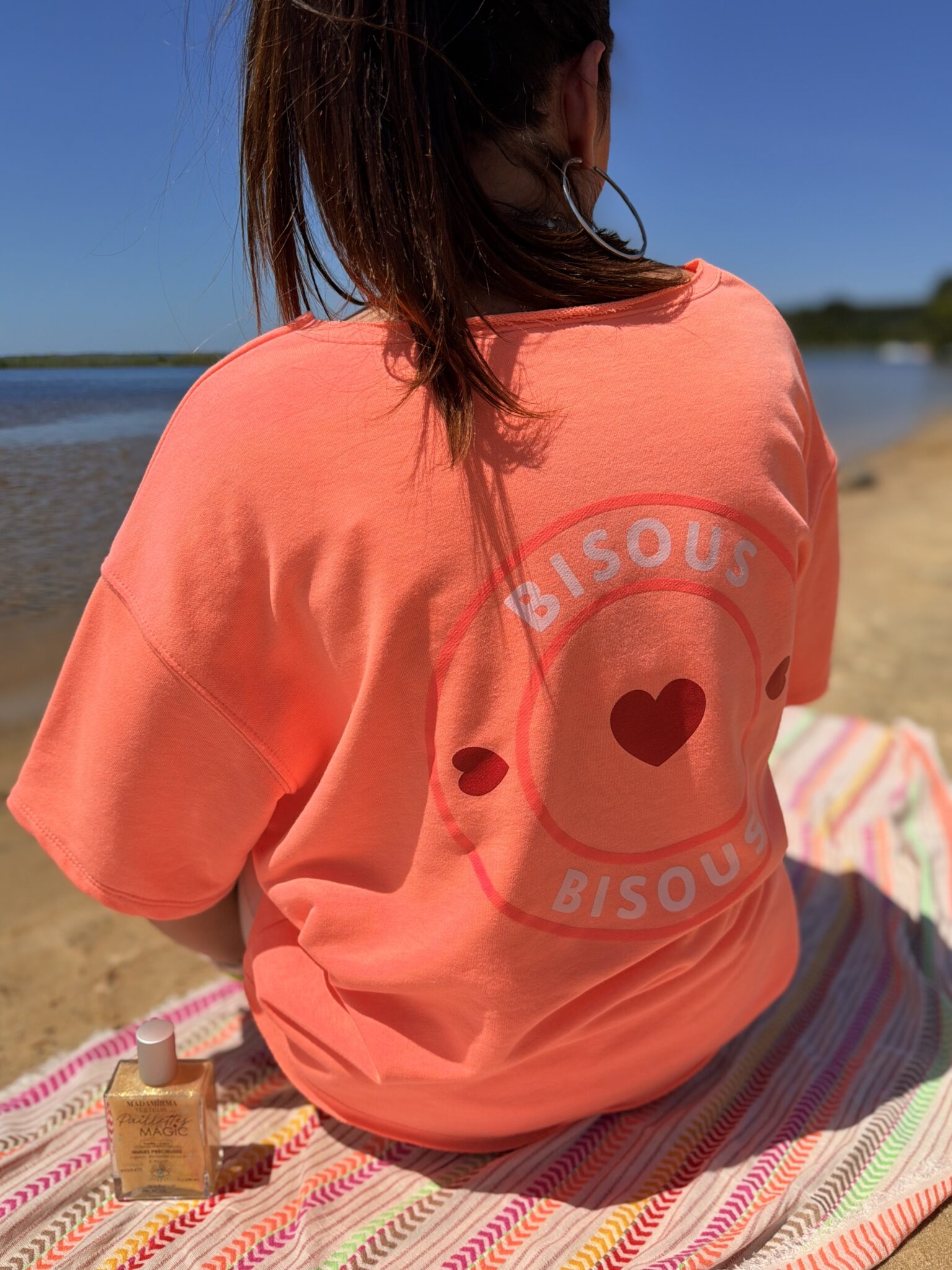 femme brune porte t-shirt oversize avec imprimé coeurs écriture bisous