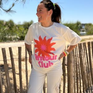 femme brune porte t-shirt blanc oversize avec un fleur et écriture amour club