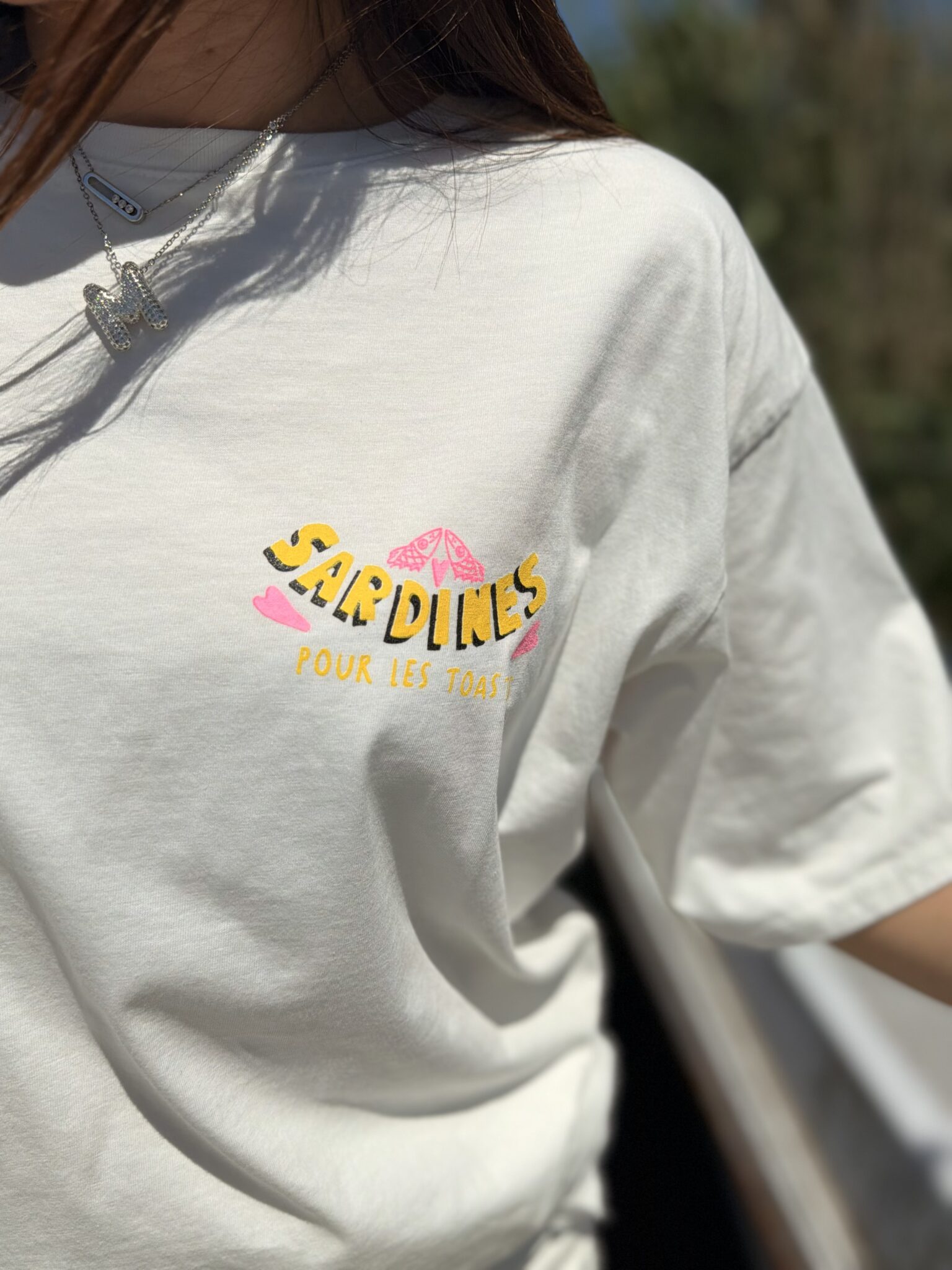 femme brune porte t-shirt blanc avec inscription sardines dans le dos