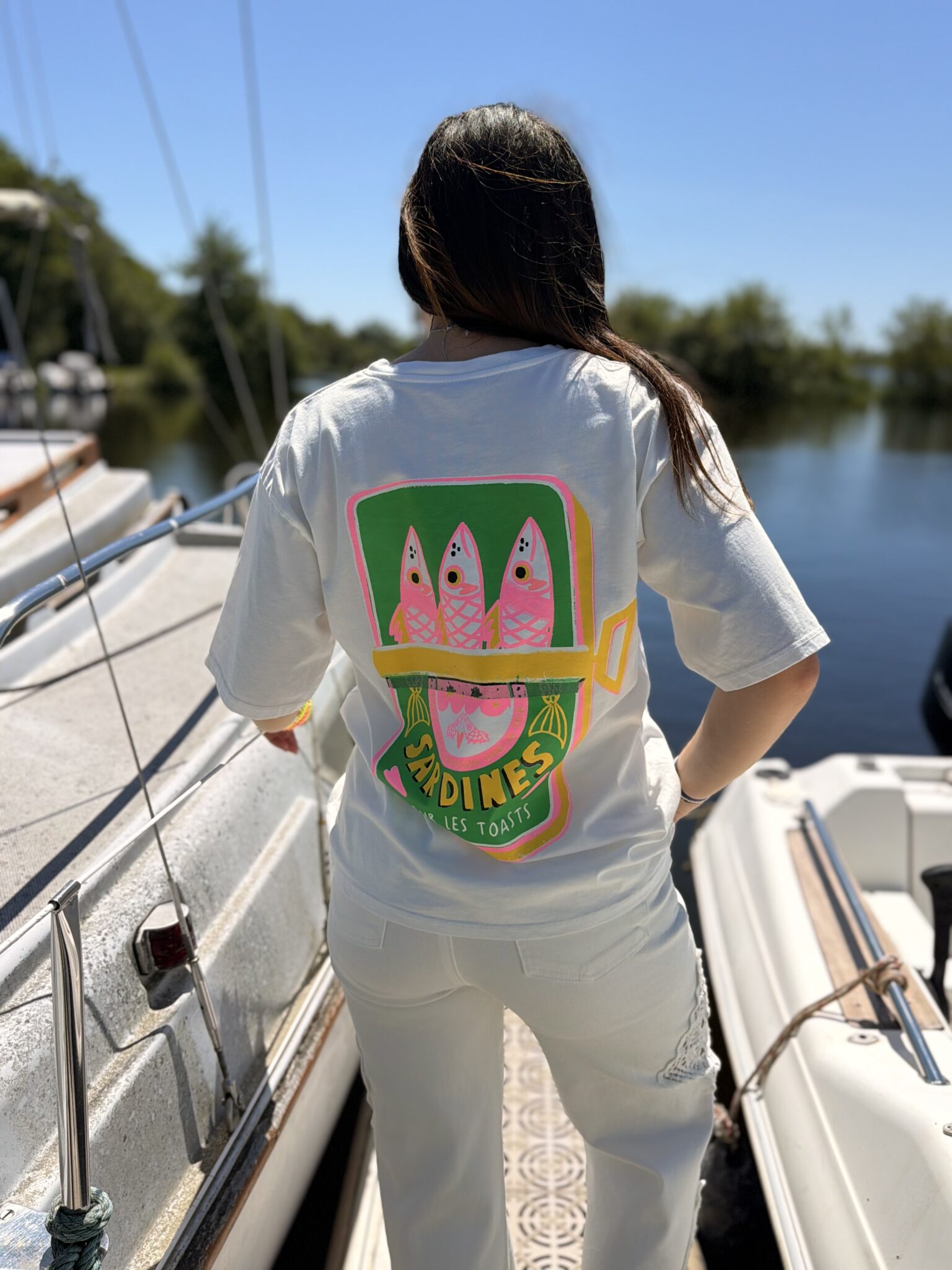 femme brune porte t-shirt blanc avec inscription sardines dans le dos