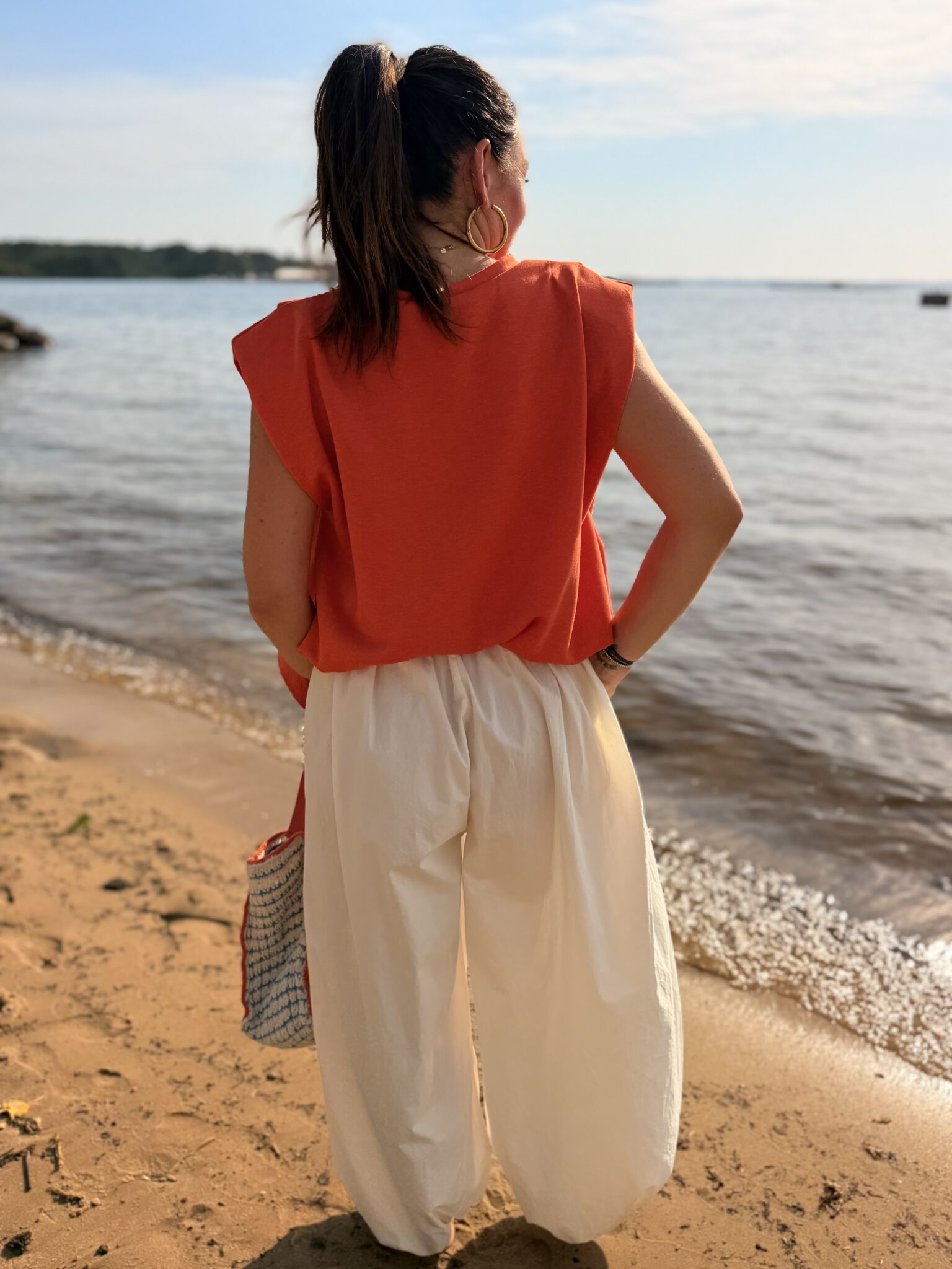femme brune porte top orange structure