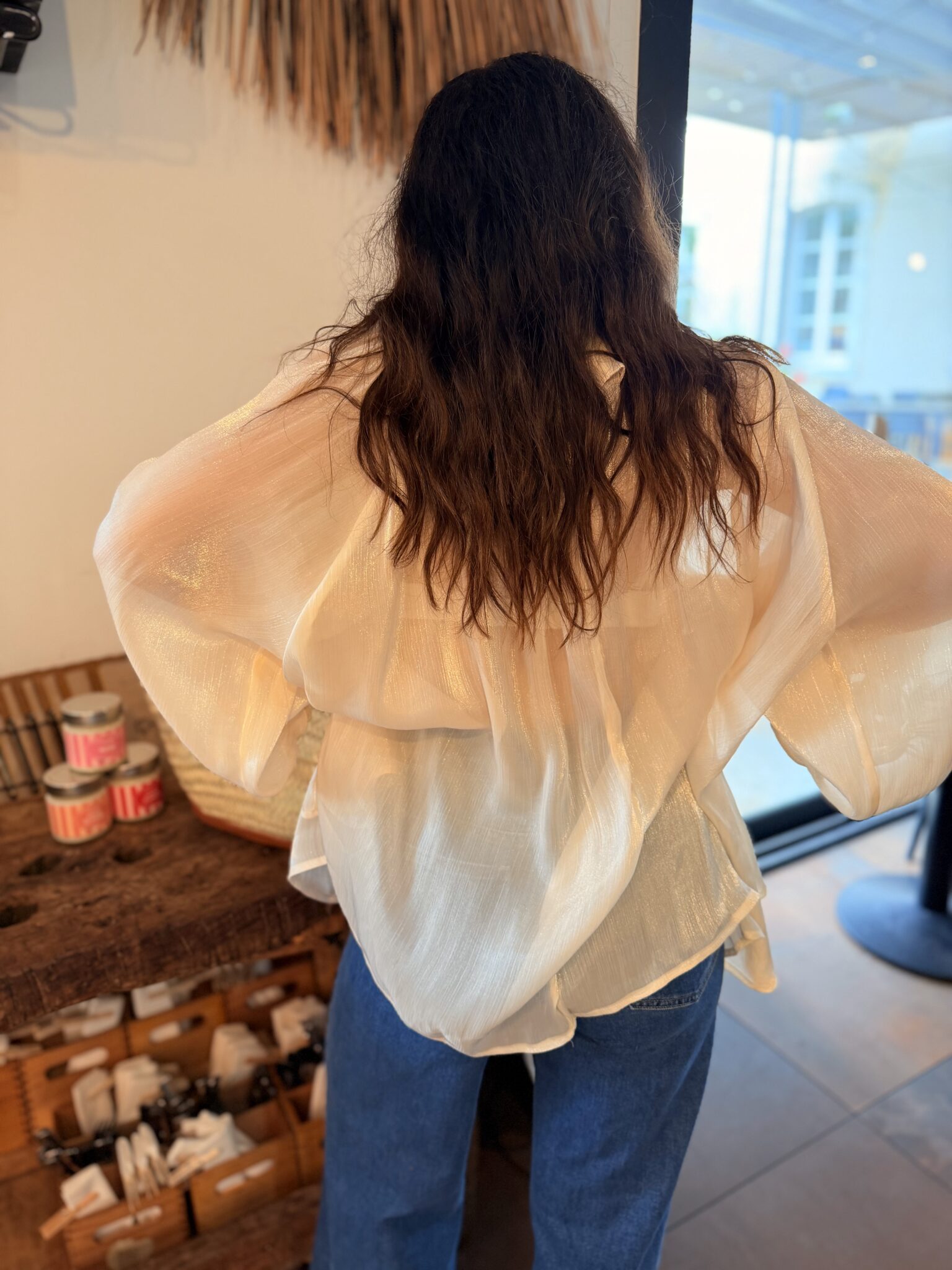 femme portant un chemisier crème dans un style bohème et voilage avec manches bouffantes