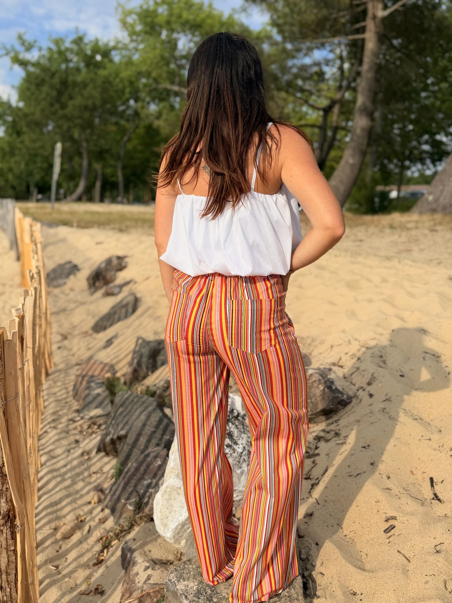 femme brune porte top blanc à bretelles fines