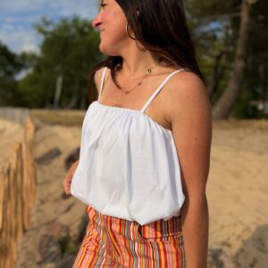 femme brune port top blanc a bretelles fines
