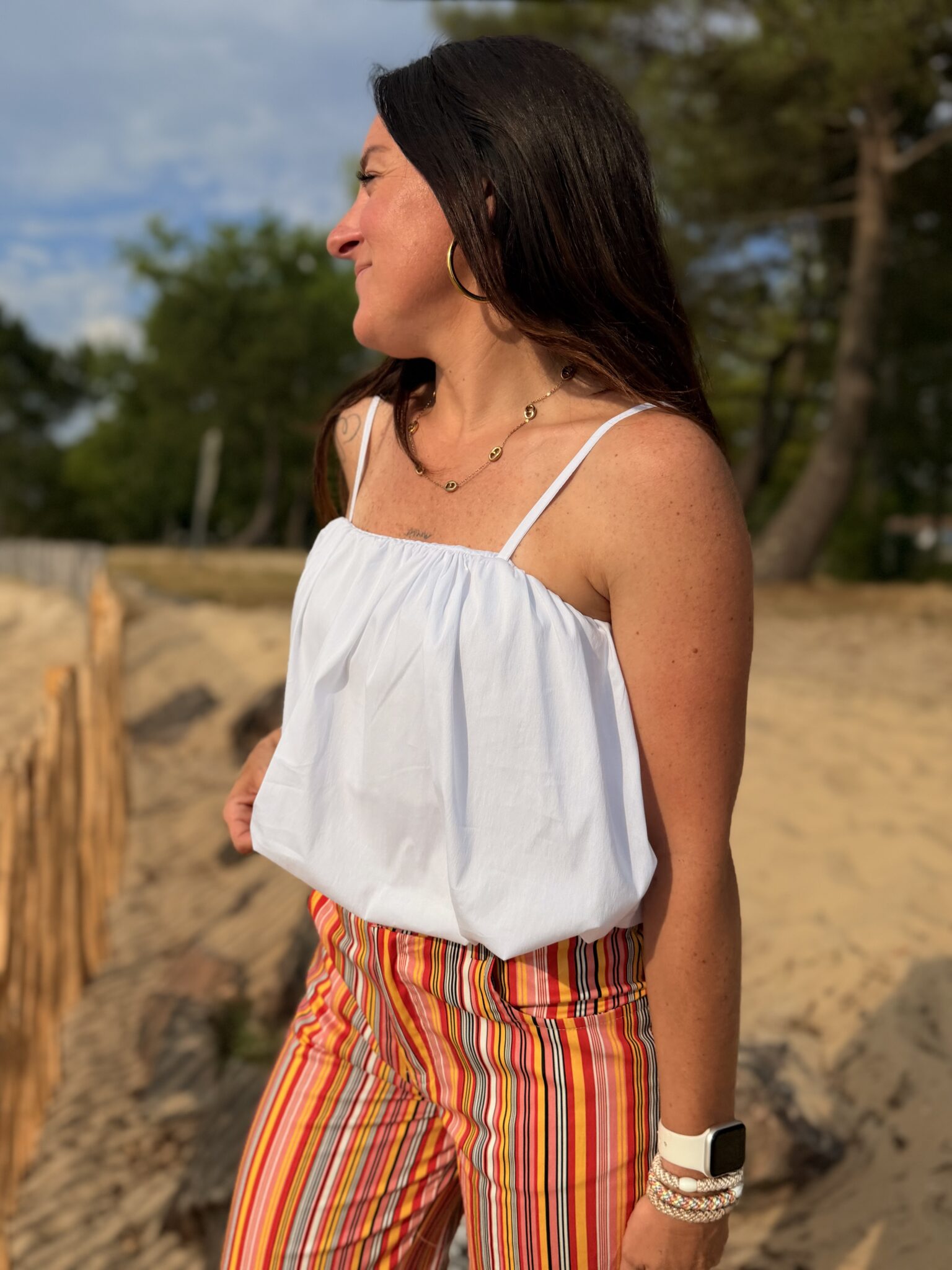 femme brune port top blanc a bretelles fines