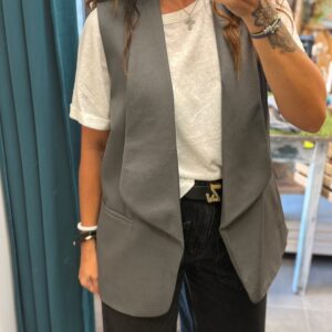 femme brune porte gilet sans manche style blazer