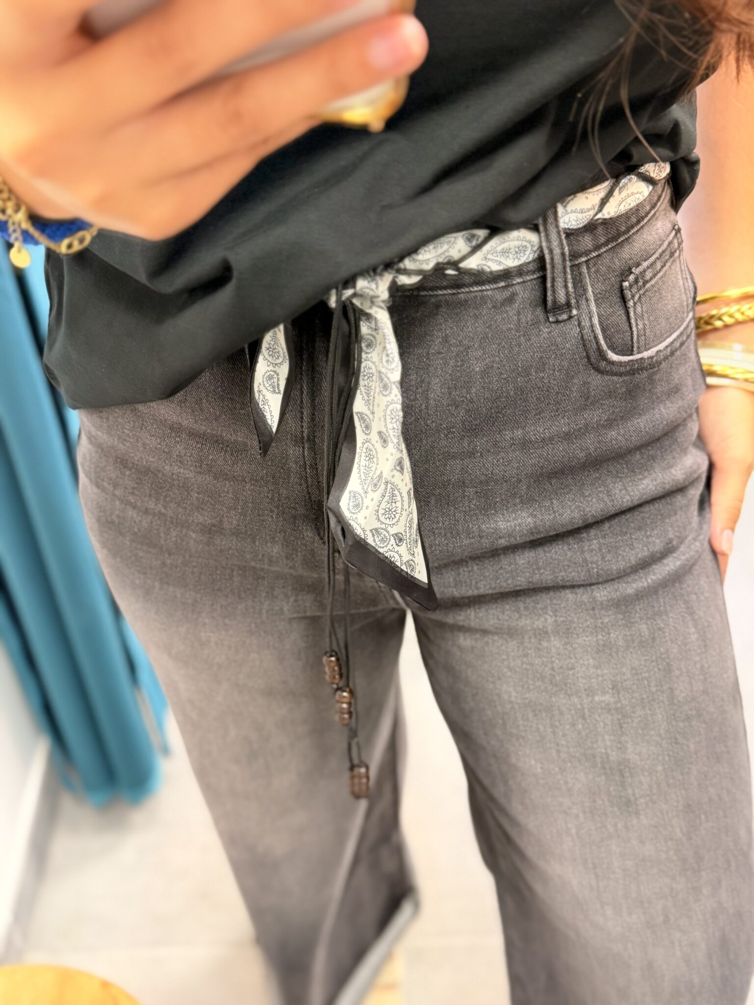 femme brune porte jean large à fausses coutures gris et noir