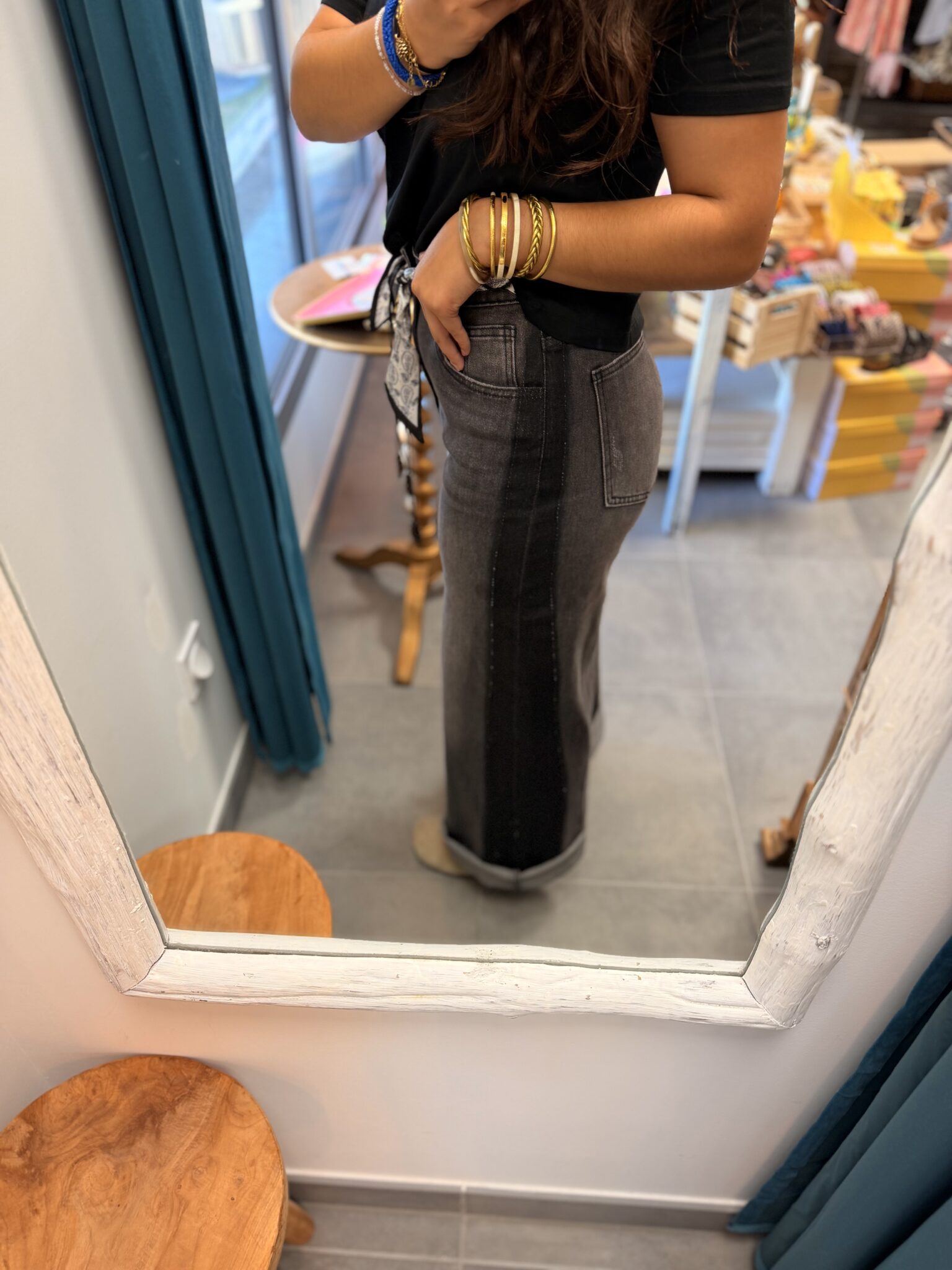 femme brune porte jean large à fausses coutures gris et noir