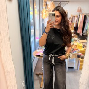 femme brune porte jean large à fausses coutures gris et noir