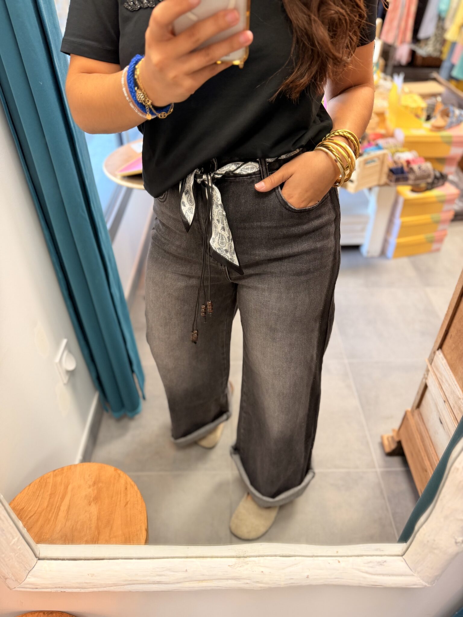 femme brune porte jean large à fausses coutures gris et noir