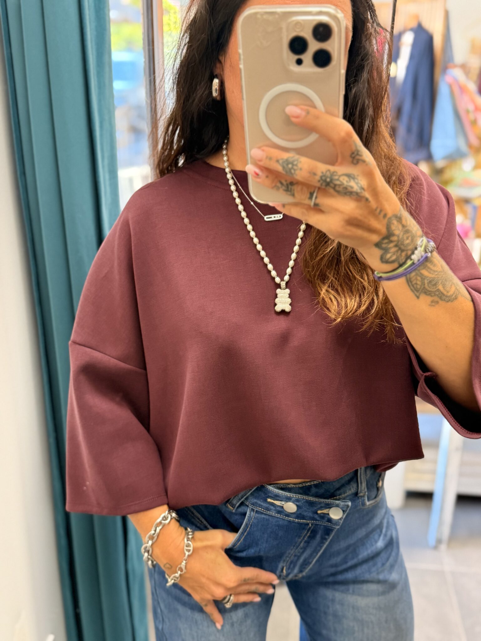 femme brune porte haut oversize bordeaux