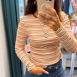 femme brune porte haut rayé à côte beige et orange